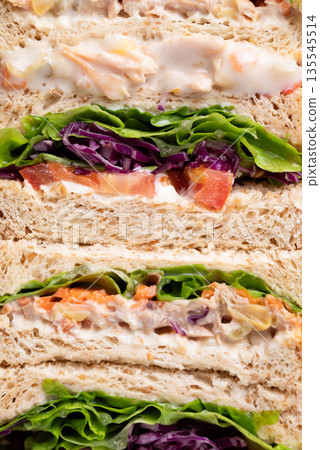 Sandwich tuna mayonnaise with whole wheat bread, lettuce, carrot, tomato and purple cabbage 135545514