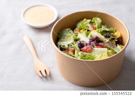 Healthy vegetable salad in takeout bowl with salad dressing ready to eating Healthy vegetable salad in takeout bowl with salad dressing ready to eating 135545522