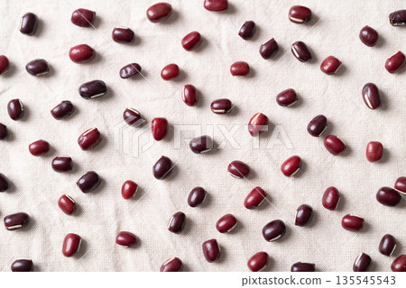 Azuki beans, Adzuki bean or red mung beans on white fabric background Azuki beans, Adzuki bean or red mung beans on white fabric background 135545543
