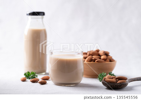 Almond milk and almond nuts on white fabric background, Alternative milk made from plant, Dairy free Almond milk and almond nuts on white fabric background, Alternative milk made from plant, Dairy free 135545556