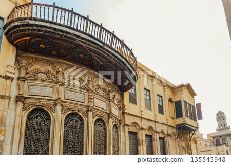 Historic Qalawun Complex in Cairo, featuring intricate architecture, tall minarets, and domes under a blue sky with clouds. A significant cultural landmark on Al-Muizz Street. Historic Qalawun Complex in Cairo, featuring intricate architecture, tall minarets, and domes under a blue sky with clouds. A significant cultural landmark on Al-Muizz Street. 135545948