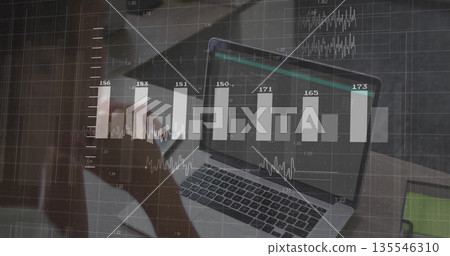Holding smartphone while woman typing on laptop computer at wooden desk, with overlaid data charts Holding smartphone while woman typing on laptop computer at wooden desk, with overlaid data charts 135546310