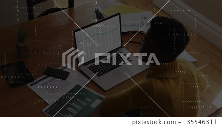 Working woman in sweater viewing spreadsheet on laptop at home, with smartphone charts, copy space 135546311