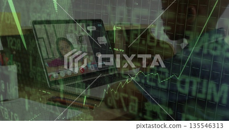 Laptop displaying pink top child calling at home, with pen holder, cup, notepad, green stock charts Laptop displaying pink top child calling at home, with pen holder, cup, notepad, green stock charts 135546313