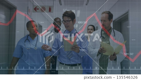 Team in scrubs walking in hospital corridor, reviewing charts with clipboards and red graph grid Team in scrubs walking in hospital corridor, reviewing charts with clipboards and red graph grid 135546326