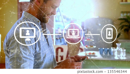 Smiling man holding smartphone in home kitchen, showing network icons with potted plant, copy space Smiling man holding smartphone in home kitchen, showing network icons with potted plant, copy space 135546344
