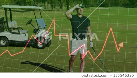 Shading eyes holding club, polo golfer on fairway, with golf cart, sun visor, glove, grid overlay 135546350