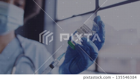 Drawing fluid by clinician's gloved hand in clinic, with COVID-19 vial, syringe and stethoscope Drawing fluid by clinician's gloved hand in clinic, with COVID-19 vial, syringe and stethoscope 135546384