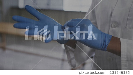 Pulling on blue gloves, technician in lab coat adjusting glove at lab bench, with chart overlay 135546385