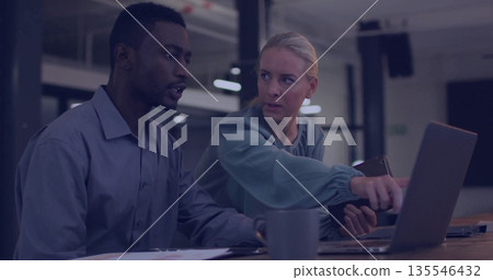 Pointing coworker with tablet guiding colleague at office, with laptop papers smartphone coffee mug Pointing coworker with tablet guiding colleague at office, with laptop papers smartphone coffee mug 135546432