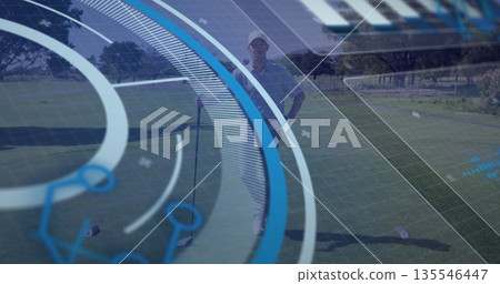 Standing mature golfer analyzing AR overlay on putting green, with golf ball and putter Standing mature golfer analyzing AR overlay on putting green, with golf ball and putter 135546447