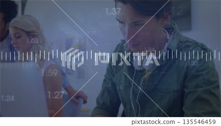 Working man wearing headphones at office with laptops and waveform graphics, copy space Working man wearing headphones at office with laptops and waveform graphics, copy space 135546459