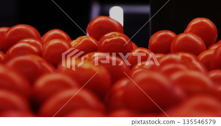 Displaying ripe red tomatoes piling together in produce section, with crate edge and bright light Displaying ripe red tomatoes piling together in produce section, with crate edge and bright light 135546579