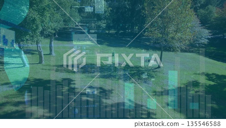 Projecting translucent bar charts line graphs and globe icons over park lawn, with wooden benches 135546588