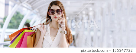 Banner Shopping bags of women crazy shopaholic person at fashion mall. Web Banner Woman love online shopping website holding shopping bags in hands with copy space. digital marketing happy lifestyle 135547722