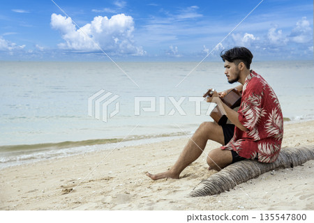 Young men playing acoustic guitar on the beach. Happy man person playing acoustic guitar music instrument seaside sitting on sand tropical beach island. Asian musician Happy guitarist hobby lifestyle Young men playing acoustic guitar on the beach. Happy man person playing acoustic guitar music instrument seaside sitting on sand tropical beach island. Asian musician Happy guitarist hobby lifestyle 135547800