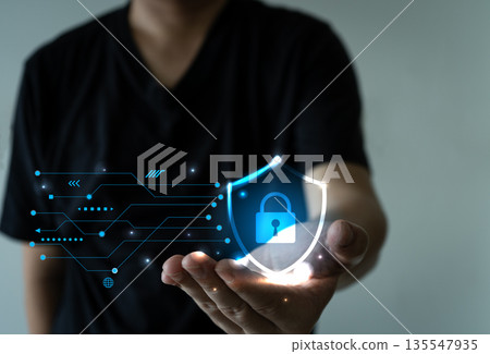 Hand holding glowing digital shield with lock and data lines, symbolizing cybersecurity 135547935