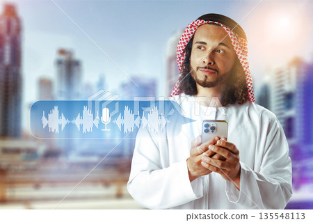 Man using smartphone to send voice message in city with tall buildings 135548113