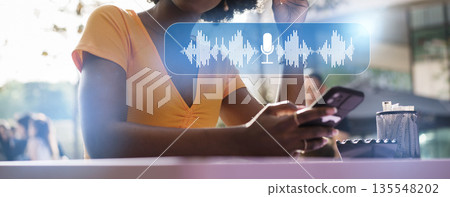 Using a smartphone for voice commands in a cafe setting during daytime 135548202