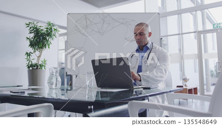 Working doctor typing on laptop at medical office conference table, with stethoscope, copy space Working doctor typing on laptop at medical office conference table, with stethoscope, copy space 135548649