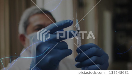 Drawing fluid into syringe by medical worker in clinic room, with white coat, mask, hairnet, gloves 135548681