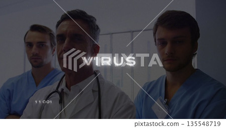 Standing doctor and scrub-clad staff consulting in hospital corridor, with stethoscope and badges Standing doctor and scrub-clad staff consulting in hospital corridor, with stethoscope and badges 135548719