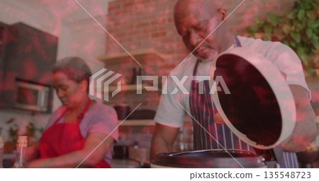 Chopping vegetables on board, woman in red apron prepping in home kitchen, partner lifting pot lid Chopping vegetables on board, woman in red apron prepping in home kitchen, partner lifting pot lid 135548723