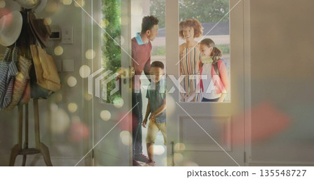 Family entering foyer via white front door glass panels, coat rack with tote bags and backpack Family entering foyer via white front door glass panels, coat rack with tote bags and backpack 135548727