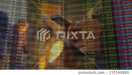 Gripping male hand tracking live stock market data on smartphone at office desk, finance theme 135548869