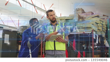 Examining tablet coworkers working on inventory in warehouse with walking cane, red lifting straps Examining tablet coworkers working on inventory in warehouse with walking cane, red lifting straps 135549046