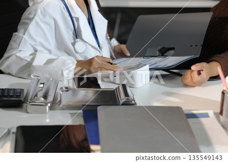A doctor's hands carefully taking a patient's blood pressure using a sphygmomanometer. A doctor's hands carefully taking a patient's blood pressure using a sphygmomanometer. 135549143