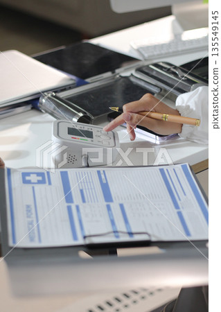 A doctor's hands carefully taking a patient's blood pressure using a sphygmomanometer. A doctor's hands carefully taking a patient's blood pressure using a sphygmomanometer. 135549145