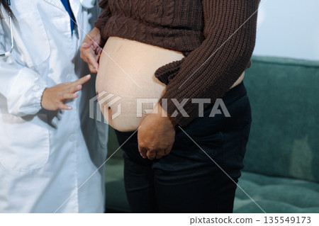 cropped shot of doctor examining pregnant woman during medical consultation cropped shot of doctor examining pregnant woman during medical consultation 135549173