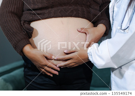 cropped shot of doctor examining pregnant woman during medical consultation cropped shot of doctor examining pregnant woman during medical consultation 135549174