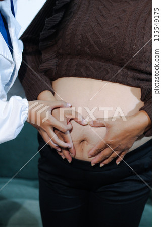 cropped shot of doctor examining pregnant woman during medical consultation cropped shot of doctor examining pregnant woman during medical consultation 135549175