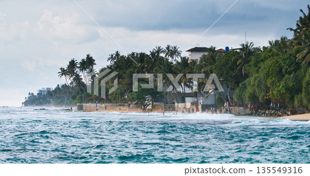 Unawatuna Beach Coastal Panorama with Palm Trees and Stone Structures Unawatuna Beach Coastal Panorama with Palm Trees and Stone Structures 135549316