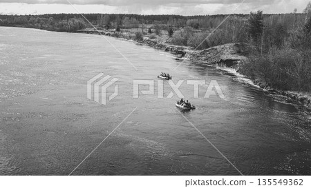 Men Dressed As US American Soldiers Of USA Infantry Of World War II carry out rafting on rubber boats In spring Autumn Day. Group of Soldiers people are preparing to disembark. Aerial view elevated Men Dressed As US American Soldiers Of USA Infantry Of World War II carry out rafting on rubber boats In spring Autumn Day. Group of Soldiers people are preparing to disembark. Aerial view elevated 135549362