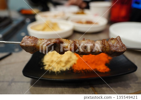 Juicy grilled lamb skewer with cumin and chili spices, a popular Chinese street food 135549421