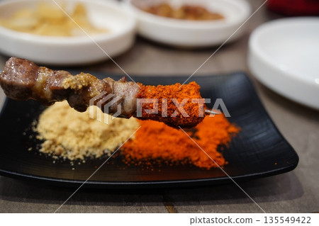 Juicy grilled lamb skewer with cumin and chili spices, a popular Chinese street food Juicy grilled lamb skewer with cumin and chili spices, a popular Chinese street food 135549422