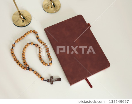 Catholic corner at home. Wooden rosary beads, cross, and prayer book. Faith, symbols, and traditions. 135549637