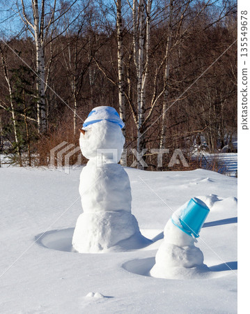 Snowmen stuck in a snowdrift. Sunny winter day 135549678