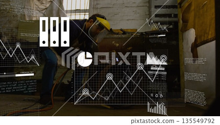 Welder wearing yellow helmet with face shield welding metal chest in workshop, data overlays Welder wearing yellow helmet with face shield welding metal chest in workshop, data overlays 135549792