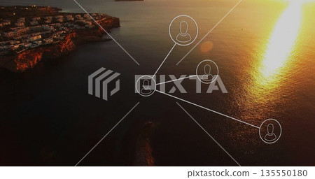 Floating network connecting user icons above cliffside village at sunset, with sun reflection Floating network connecting user icons above cliffside village at sunset, with sun reflection 135550180