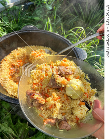 Pilaf is cooked in a cauldron Pilaf is cooked in a cauldron 135550219