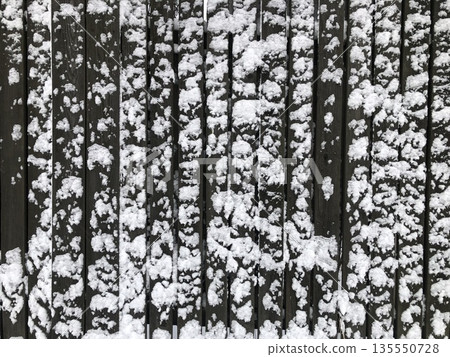 wooden fence covered with white snow 135550728