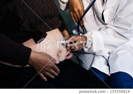 cropped shot of doctor examining pregnant woman during medical consultation cropped shot of doctor examining pregnant woman during medical consultation 135550814