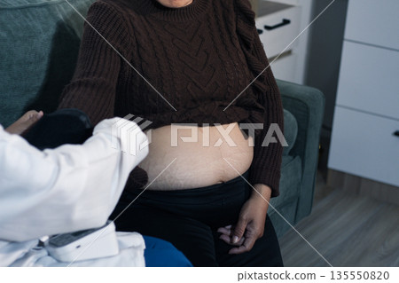 cropped shot of doctor examining pregnant woman during medical consultation cropped shot of doctor examining pregnant woman during medical consultation 135550820
