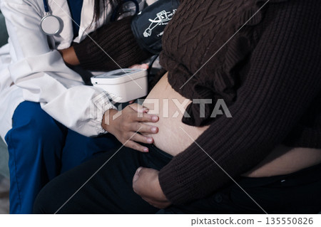 cropped shot of doctor examining pregnant woman during medical consultation cropped shot of doctor examining pregnant woman during medical consultation 135550826
