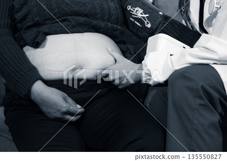 cropped shot of doctor examining pregnant woman during medical consultation cropped shot of doctor examining pregnant woman during medical consultation 135550827