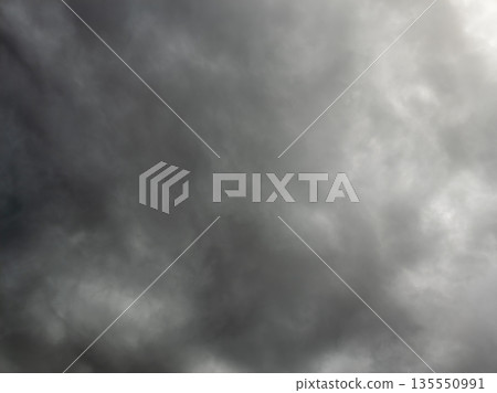 Ominous clouds gathering over dark sky during daytime 135550991